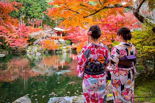 Due donne giapponesi in kimono contemplano i momiji a Kyoto